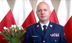 Na zdjęciu Komendant Główny Policji gen. insp. Jarosław Szymczyk. Za Komendantem flagi Polski, a po jego prawej stronie wazon z tulipanami.