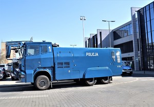 Na zdjęciu pojazd policyjny typu armatka wodna. W tle widoczny fragment stadionu.