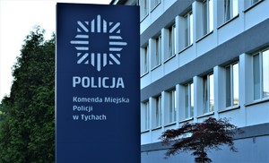 Na zdjęciu budynek oraz stojąca przed nim tablica z logiem Policji oraz napisem o treści: Policja Komenda Miejska Policji w Tychach.