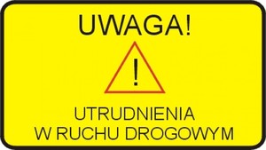 Na grafice, na żółtym tle znak ostrzegawczy w kształcie trójkąta z umieszczonym w środku wykrzyknikiem. Poniżej napis o treści - uwaga utrudnienia w ruchu drogowym.