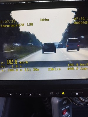 Na zdjęciu obraz z wideorejestratora, na którym widać dwa samochody jadące równolegle na drodze dwujezdniowej.