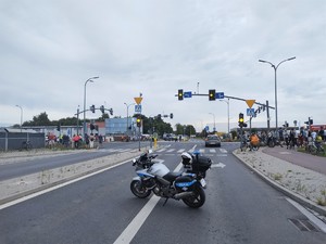 Na zdjęciu motocykl policyjny zaparkowany w rejonie skrzyżowania.