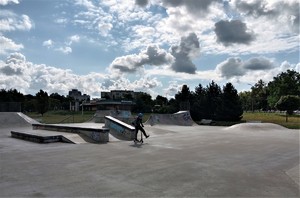 Chłopiec w skateparku jeżdżący na hulajnodze.