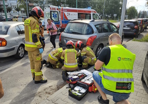 Na zdjęciu strażacy przeprowadzający akcje ratowniczą. Obok osoby postronne robiące zdjęcia.