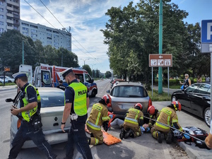 Na zdjęciu strażacy przeprowadzający akcje ratowniczą. Obok policjanci oraz osoby postronne.