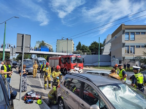 Na zdjęciu strażacy, ratownik medyczny oraz policjanci i osoby postronne podczas symulacji zdarzenia drogowego.