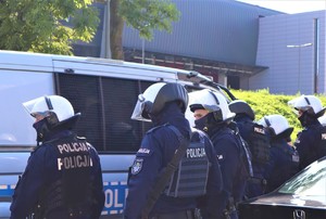 Na zdjęciu umundurowani policjanci z oddziałów prewencji podczas przemarszu kibiców na stadion.