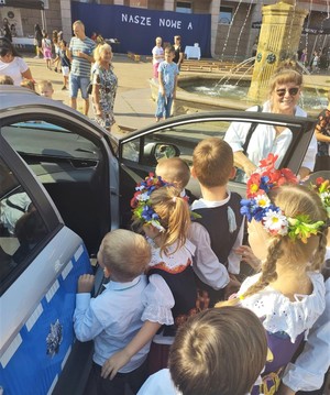 Na zdjęciu policyjny radiowóz i dzieci.