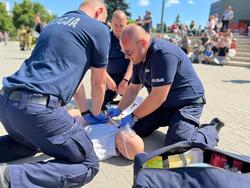 Na zdjęciu policjanci, którzy klęczą przy fantomie podczas ćwiczeń z udzielania pierwszej pomocy.