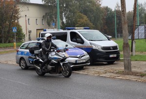 Na zdjęciu motocykl i radiowóz policyjny oraz wóz straży miejskiej.