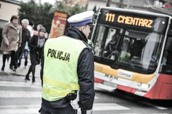 Policjant z drogówki kierujący ruchem - w tle autobus