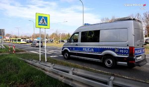 Policyjny radiowóz na drodze, w tle autobus komunikacji miejskiej.