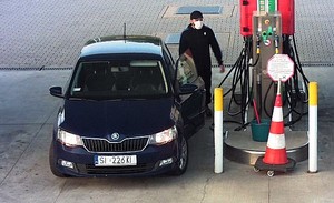 Na zdjęciu mężczyzna w wieku około 30-35 lat, ubrany w sportowe buty, czarne spodnie z czerwonym pakiem, czarną bluzę z niebieskim pakiem, czarną czapkę z daszkiem, na twarzy założona maseczka ochronna.