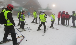 Na zdjęciu osoby na nartach w kamizelkach odblaskowych.