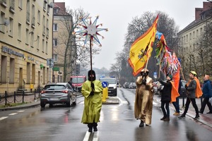 Zdjęcie przedstawia orszak Trzech Króli idący ulicami miasta.