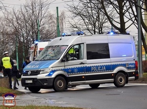 Na zdjęciu policyjny radiowóz oraz stojący obok niego umundurowany policjant.