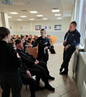 Na zdjęciu uczniowie klasy o profilu policyjnym na spotkaniu z umundurowanymi policjantami.