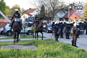 Na zdjęciu umundurowani policjanci, mundurowi na koniach oraz policyjna armatka wodna.