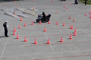 Na zdjęciu policjant jadący motocyklem po torze.