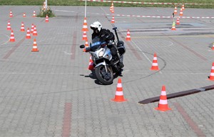 Na zdjęciu policjant jadący po torze na motocyklu.