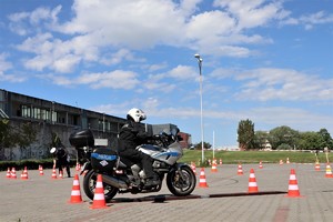 Na zdjęciu policjant jadący na motocyklu po torze.