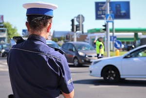 Sędzia podczas konkurencji ręcznej regulacji ruchem na skrzyżowaniu. W tle policjant.