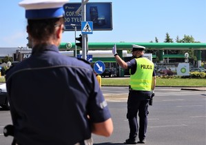 Sędzia podczas konkurencji ręcznej regulacji ruchem na skrzyżowaniu. W tle policjant.