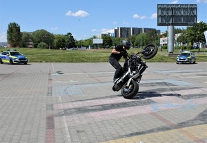 Na zdjęciu motocyklista jadący na jednym kole podczas pokazu ekstremalnej jazdy na motorze.