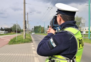 Na zdjęciu policjant ruchu drogowego mierzący prędkość.