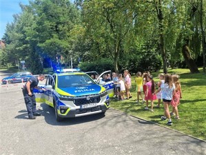 Na zdjęciu policjanci oraz dzieci obok radiowozu.