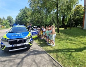 Na zdjęciu policjanci oraz dzieci obok radiowozu.