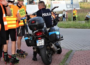 na zdjęciu policjant na motocyklu oraz organizatorzy wydarzenia