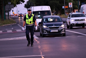 na zdjęciu policjant kierujący ruchem na skrzyżowaniu