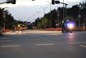 na zdjęciu policjanci na skrzyżowaniu, w tle osoby jadące na rolkach