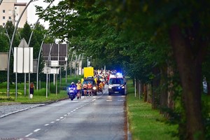 na zdjęciu policjant na motocyklu oraz osoby jadące na rolkach