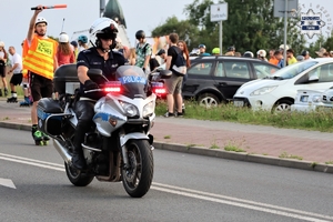 na zdjęciu policjant na motocyklu oraz osoby jadące na rolkach