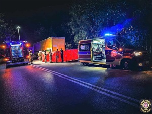 Na zdjęciu wozy straży pożarnej i pogotowie ratunkowe. Na środku parawan oraz osoby pracujące na miejscu zdarzenia