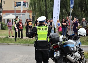 Na zdjęciu policjant ruchu drogowego stojący przy motocyklu