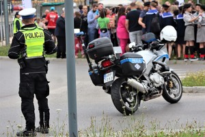 Na zdjęciu policjant ruchu drogowego stojący przy motocyklu.