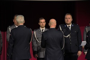 Na zdjęciu policjanci podczas wręczania i odbierania aktów nominacyjnych na wyższe stopnie służbowe.