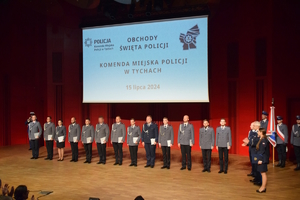 Na zdjęciu policjanci podczas uroczystości mianowania na wyższe stopnie służbowe stojący na scenie.