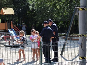 Na zdjęciu dzieci i policjanci na placu zabaw