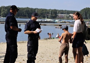 Na zdjęciu dzieci i policjanci nad brzegiem jeziora