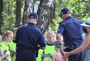 Na zdjęciu dwóch policjantów i grupa dzieci.