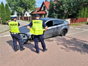 Na zdjęciu policjanci przy uszkodzonym samochodzie.