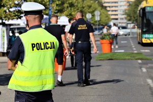 Na zdjęciu umundurowany policjant ruchu drogowego. W tle autobus.