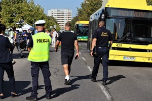 Na zdjęciu umundurowany policjant ruchu drogowego. W tle autobus.