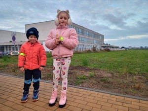 Na zdjęciu dziewczynka i chłopiec z założonymi odblaskami.