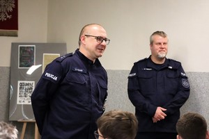 Na zdjęciu dwóch umundurowanych policjantów prowadzących prelekcję dla uczniów.