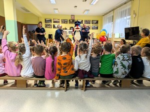 Na zdjęciu umundurowani policjanci ze Sznupkiem oraz grupa przedszkolaków